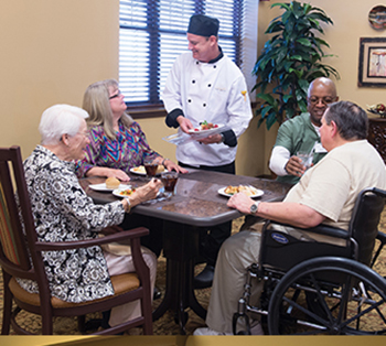 Gourmet chef serving dinner to a table of nursing home residents