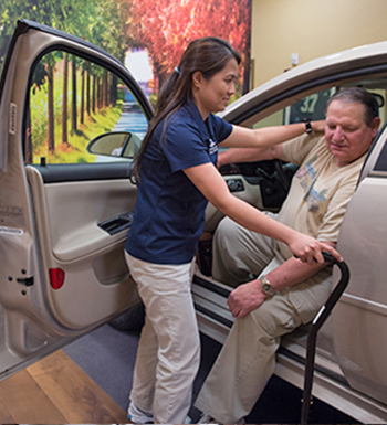 Rehab aid assisting patient with physical therapy